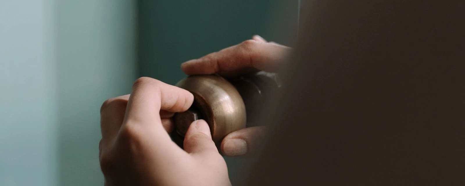 Hand turning a round brass handle